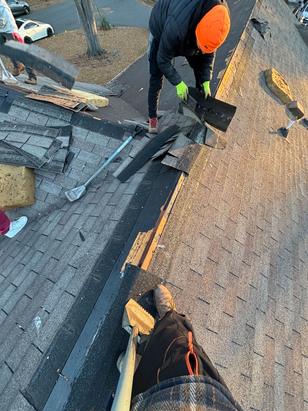 IHE crew member tearing off old shingles