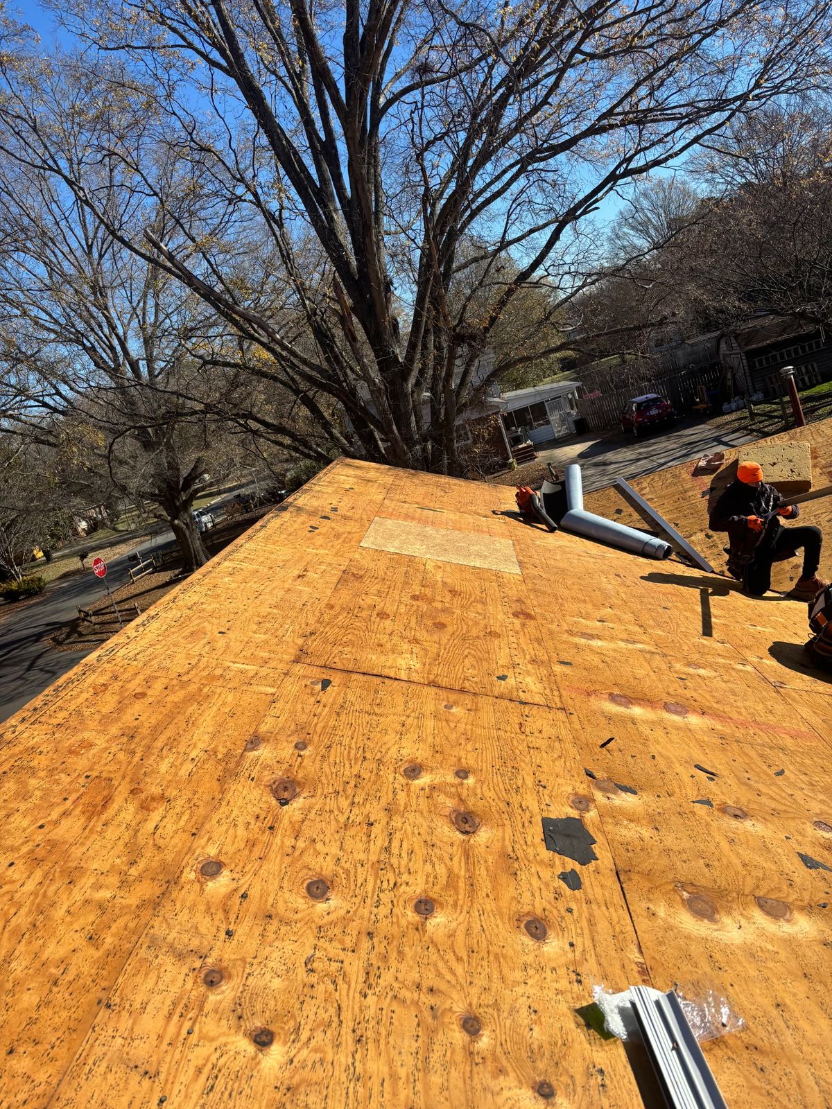 Crew working on a roof against a blue sky